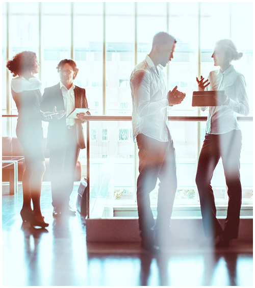 Two pairs of people having discussions in an open office space