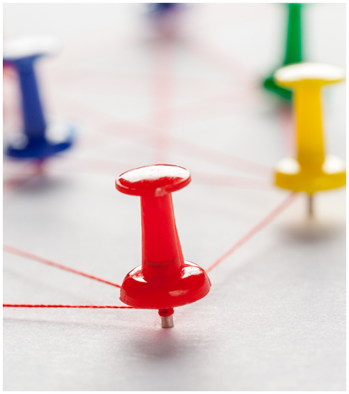 Network of colorful pushpins attached by a web of red string