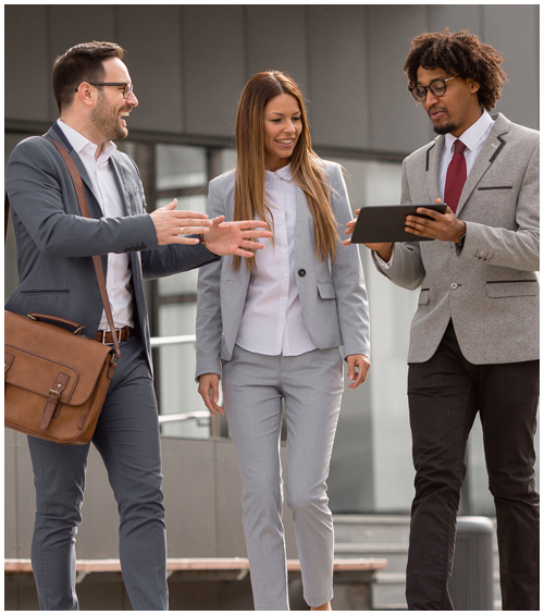 Three professionals having a discussion while viewing a tablet