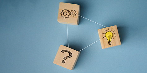 Three wooden blocks with question mark, light bulb and gear images