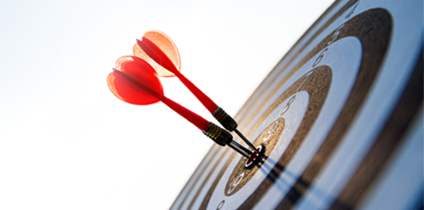 Round target with multiple darts in center of bullseye