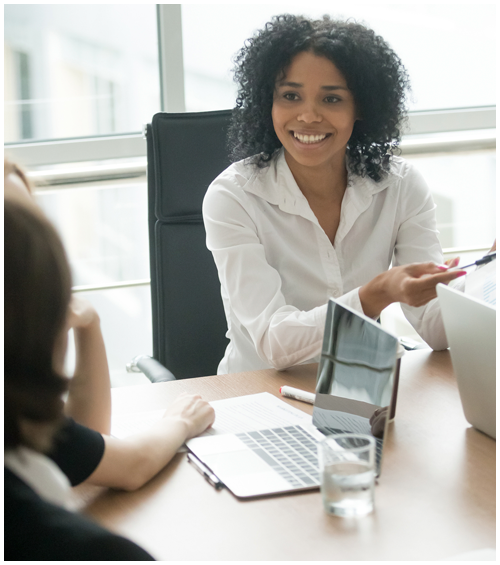 Professional woman meeting with others around a conference table